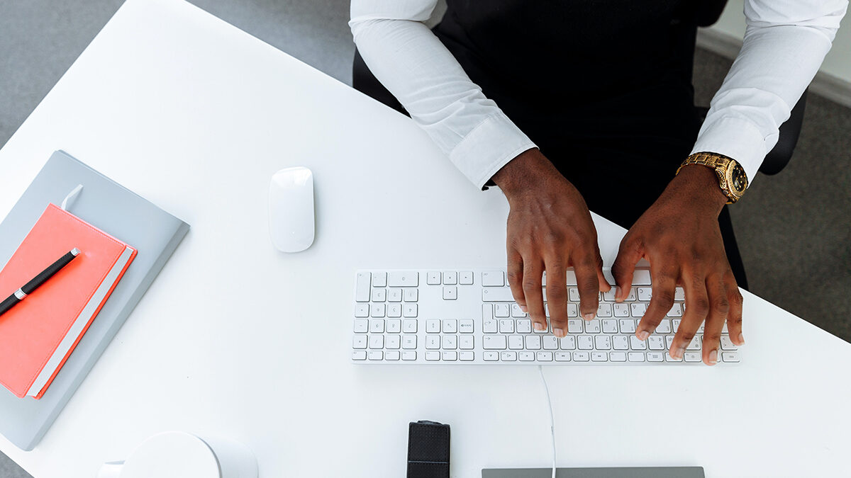 homem digitando em uma teclado branco