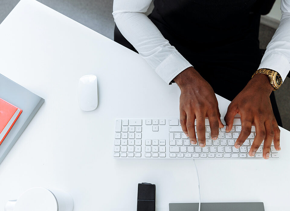 homem digitando em uma teclado branco