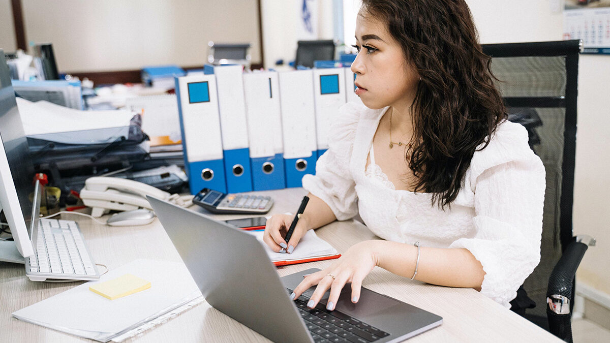 moça em escritório mexendo no notebook