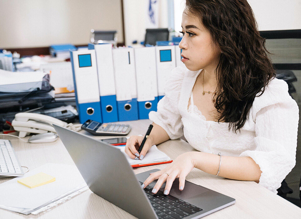 moça em escritório mexendo no notebook